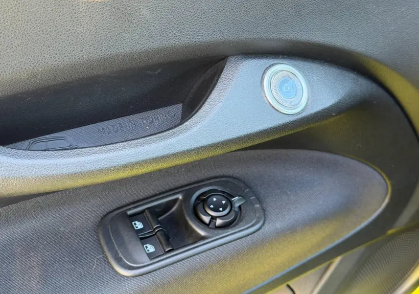 Détail de la porte côté conducteur de la Fiat 500 électrique 2024, montrant les commandes des vitres et rétroviseurs.