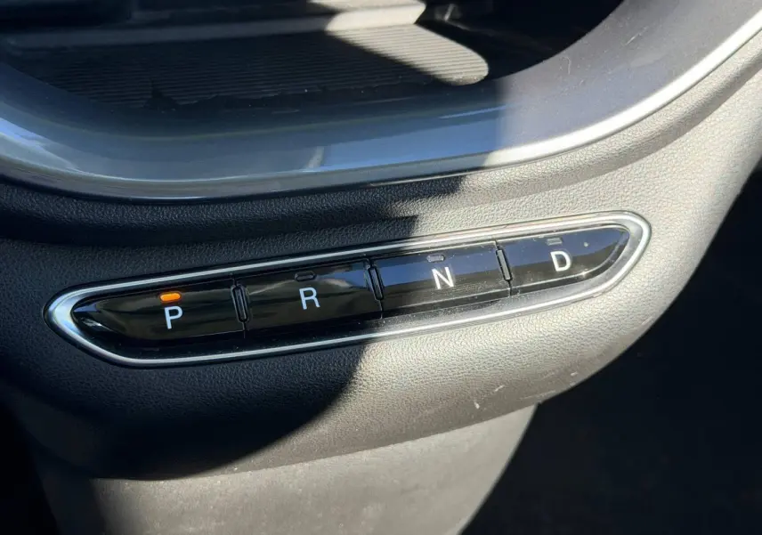 Gros plan sur la commande de boîte automatique noire avec boutons P, R, N, D dans une Fiat 500 électrique 2024 Ocean Green.
