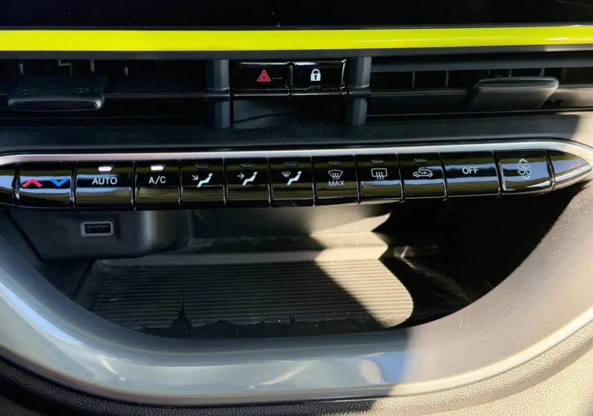 Gros plan sur la rangée de boutons de commande de climatisation dans une Fiat 500 e 95ch Pack Confort Ocean Green métal 2024.
