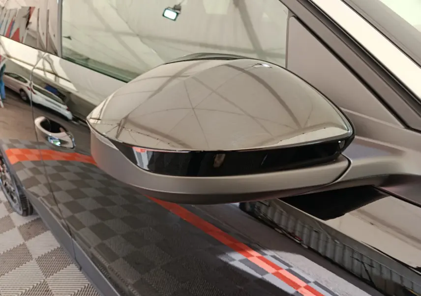 Gros plan sur le rétroviseur côté gauche noir brillant du Peugeot 3008 1.2 HYBRID 145 E-DCS6 GT 2025.