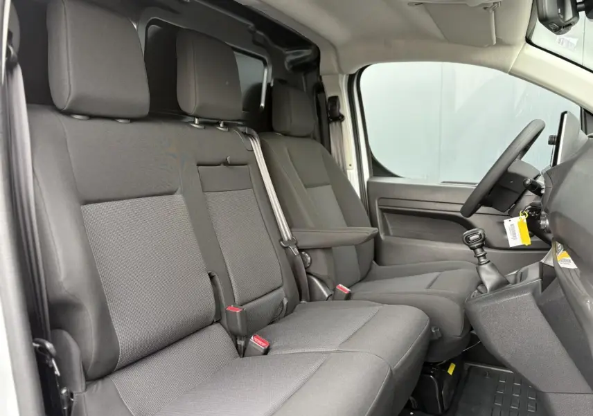 Vue intérieure côté droit du Peugeot Expert Fourgon 2025, montrant la banquette tissu bi-ton noir et gris avec siège conducteur individuel.