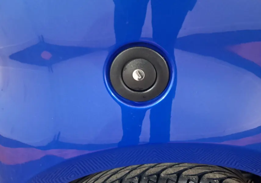 Gros plan sur la trappe de remplissage de carburant noire sur la carrosserie bleue de l'AIXAM AMBITION 2025.