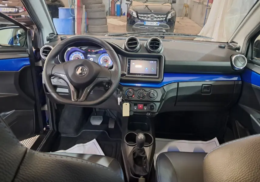 Vue intérieure de l'AIXAM AMBITION 2025 bleu, tableau de bord avec écran tactile et volant multifonction.