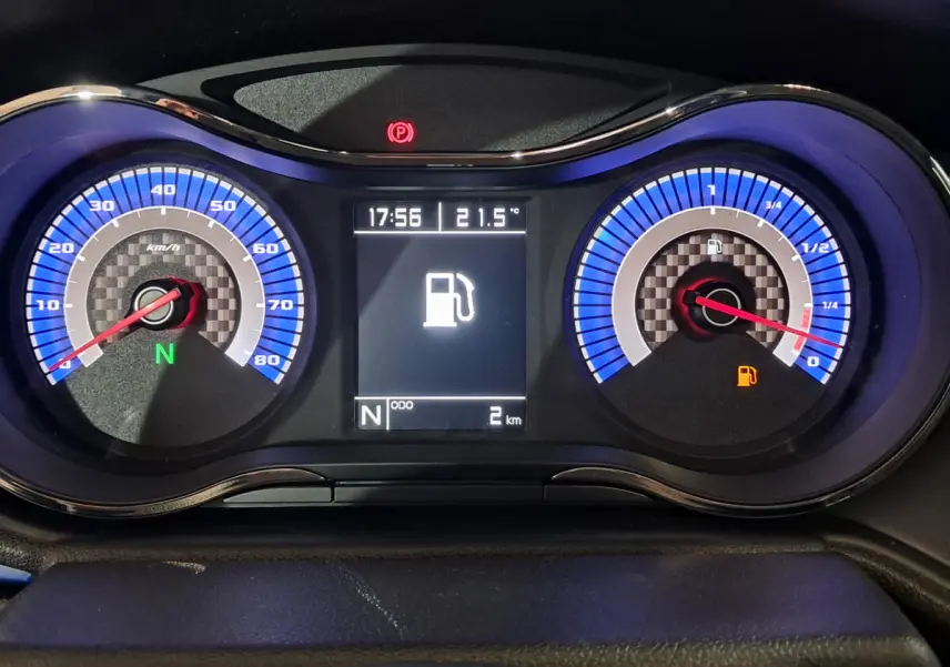 Gros plan sur le tableau de bord bleu de l'AIXAM AMBITION 2025 avec affichage numérique et jauge de carburant faible.