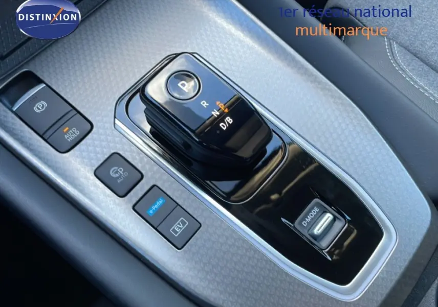 Gros plan sur la console centrale du Nissan Qashqai 2025, montrant la boîte auto et les boutons de commande en finition gris argenté.