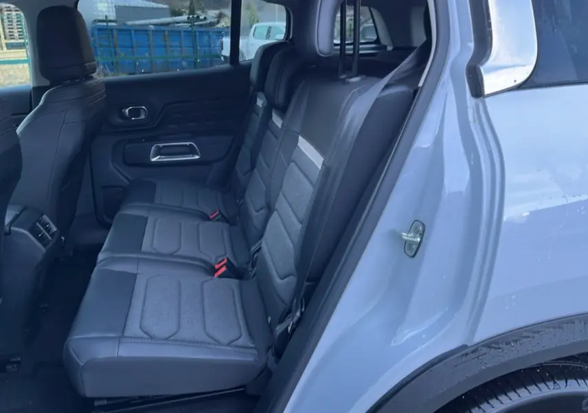 Vue intérieure côté droit des trois sièges arrière individuels gris du Citroën C5 Aircross Hybrid blanc okénite.