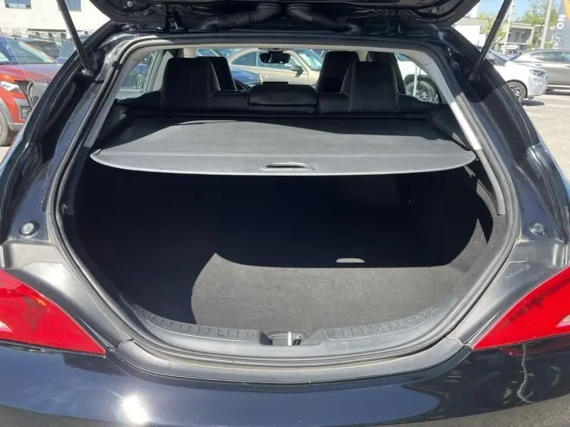 Vue arrière du coffre ouvert d'une Mercedes Classe CLA Shooting Brake noire de 2017, avec cache-bagages déployé.