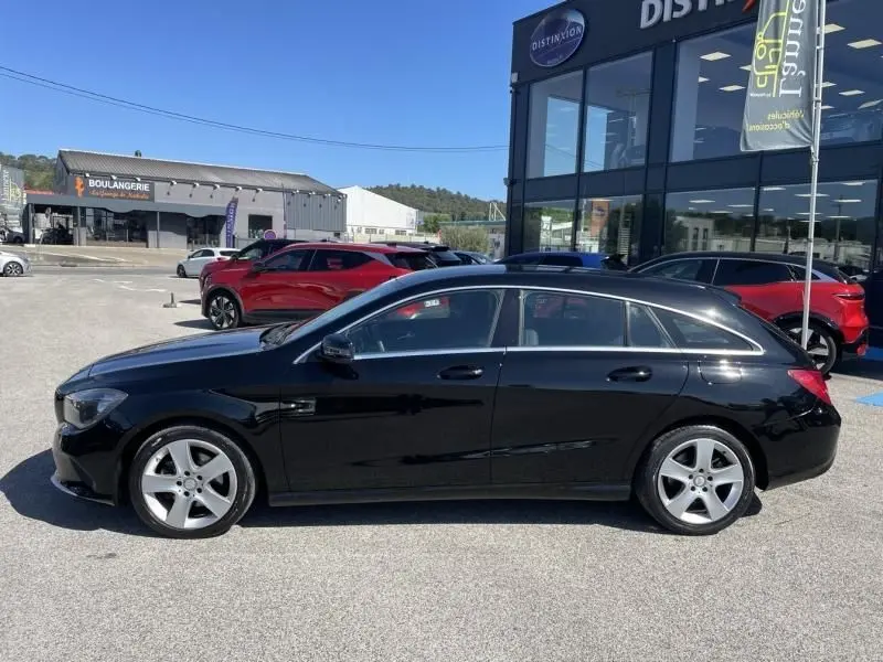 Vue de profil côté gauche d'une Mercedes Classe CLA Shooting Brake noire, avec jantes alliage et vitres teintées.