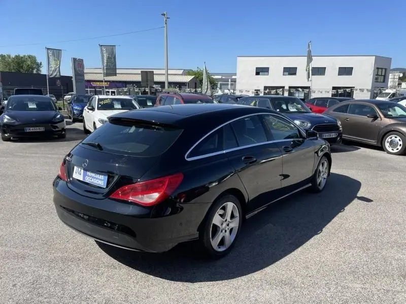 Mercedes Classe CLA Shooting Brake noir vue 3/4 arrière droit, avec feux arrière rouges et jantes alliage.