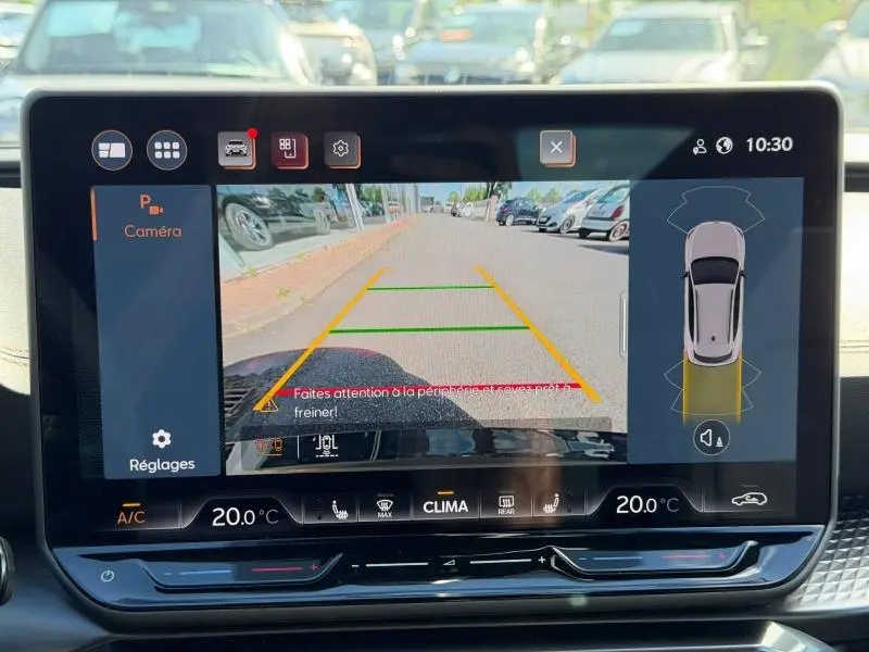 Écran tactile intérieur affichant la caméra de recul du CUPRA Formentor blanc Nevada, vue arrière avec lignes de guidage colorées.