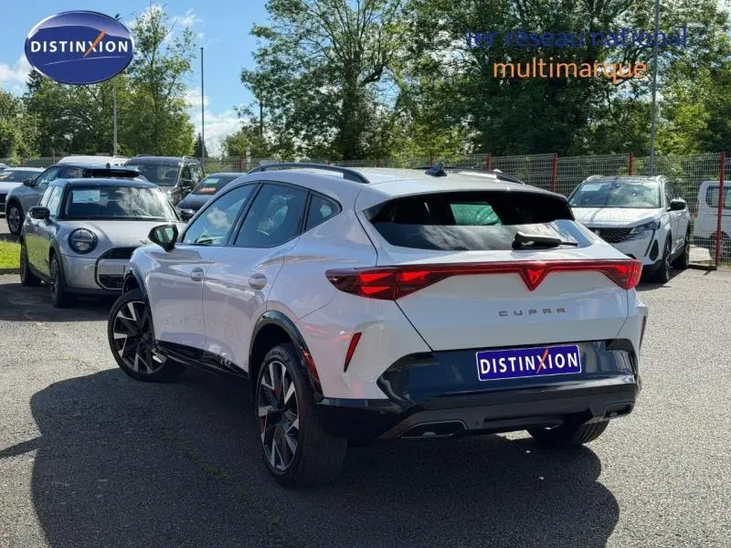 Vue 3/4 arrière droite d'un CUPRA Formentor blanc Nevada métallisé avec feux arrière LED et jantes alu noires.