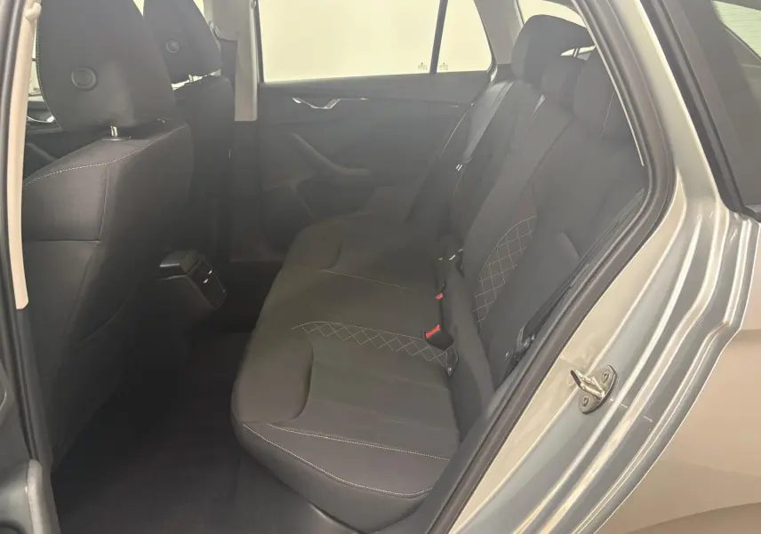Vue intérieure arrière côté droit de la Skoda Scala 2024 gris argent, montrant les sièges arrière en tissu noir avec surpiqûres.