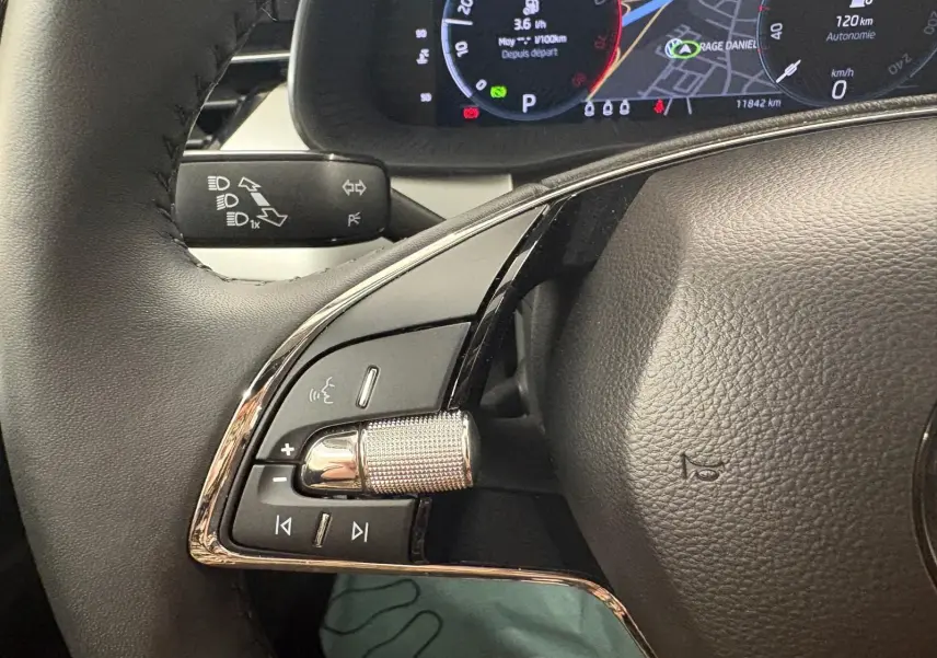 Gros plan sur le volant de la Skoda Scala gris argent 2024, montrant les commandes multifonctions et l'affichage numérique du tableau de bord.