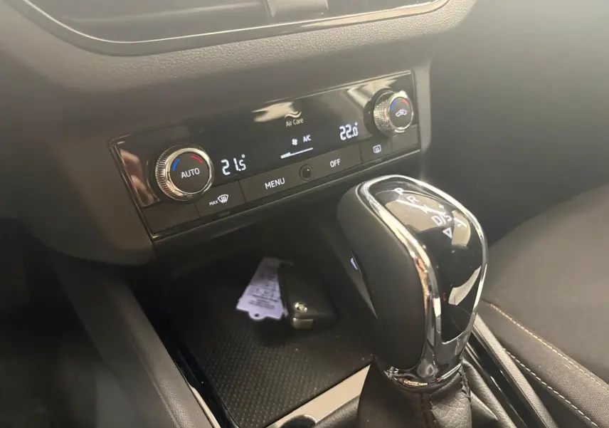 Gros plan sur la console centrale du Skoda Scala gris argent 2024, avec levier de boîte auto et commandes climatisation digitales.