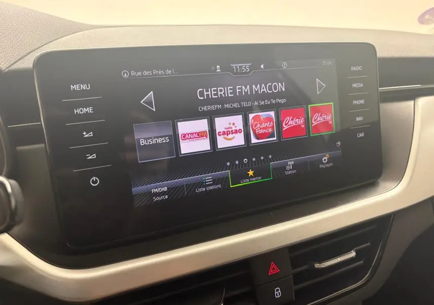 Écran tactile central du Skoda Scala 2024 gris argent, affichant la radio avec plusieurs stations FM en mode Business.