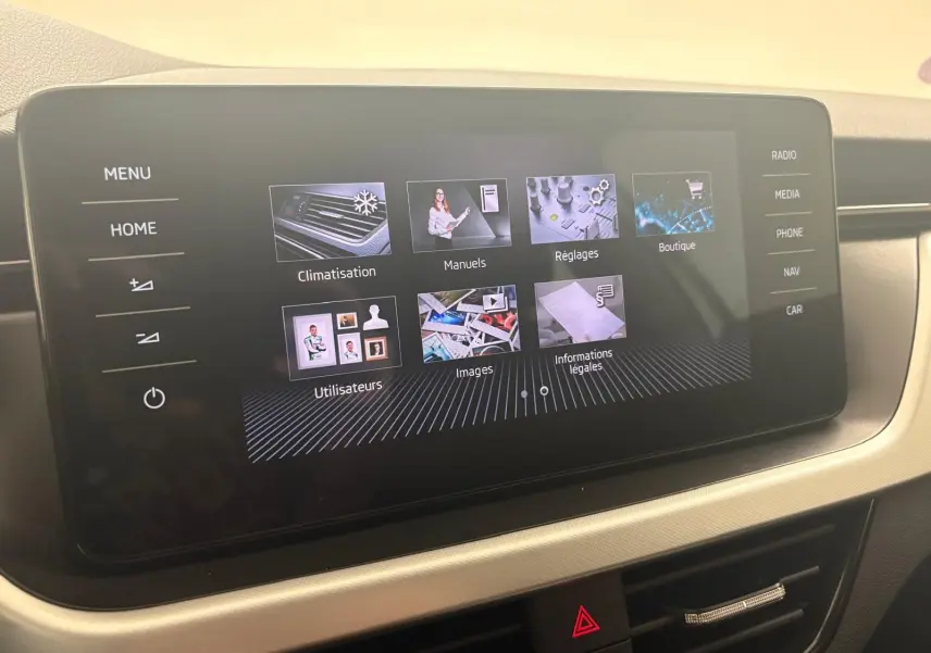 Écran tactile central du Skoda Scala 2024 affichant le menu principal avec options climatisation, manuels et réglages.