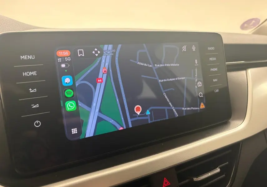 Écran tactile central du Skoda Scala 2024 affichant la navigation GPS avec commandes tactiles autour, intérieur beige.