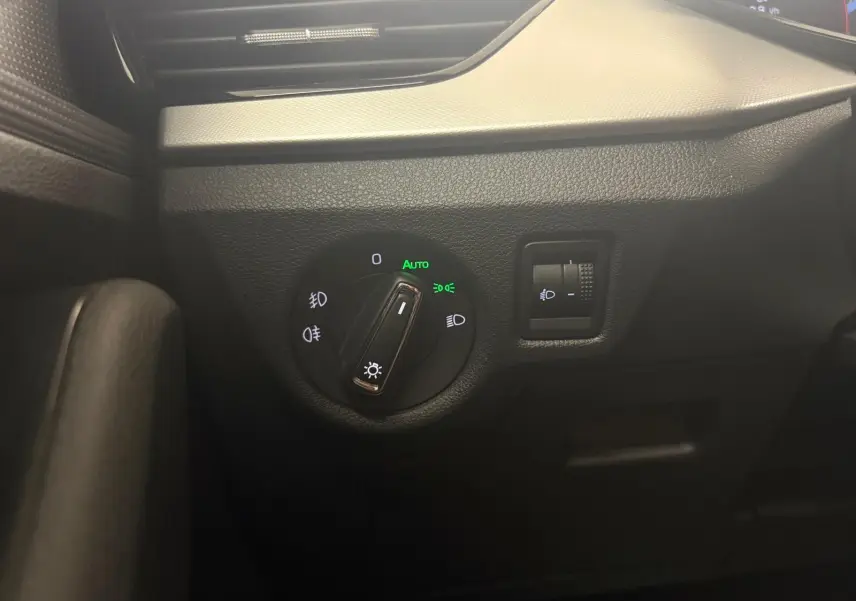 Détail du tableau de bord côté gauche du Skoda Scala 2024, montrant la commande des phares avec réglage automatique allumé.