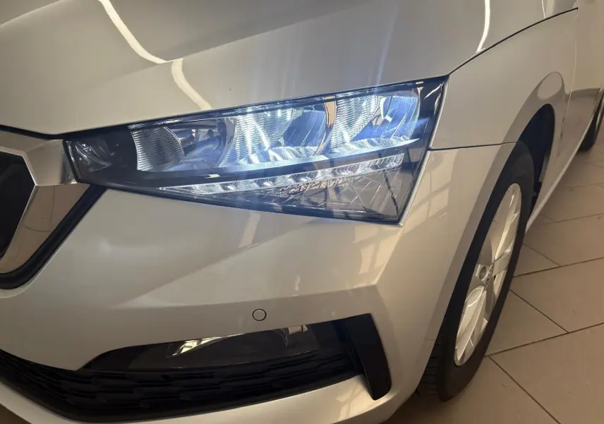 Gros plan sur le phare avant droit d'une Skoda Scala gris argent 2024 avec jante alliage visible.