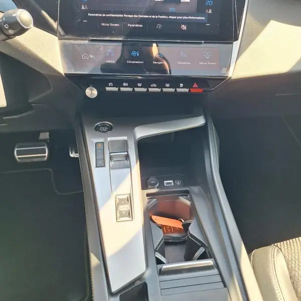 Vue rapprochée de la console centrale et du cockpit numérique de la Peugeot 308 SW Hybrid 145 e-DCS6 GT 2025, intérieur noir.