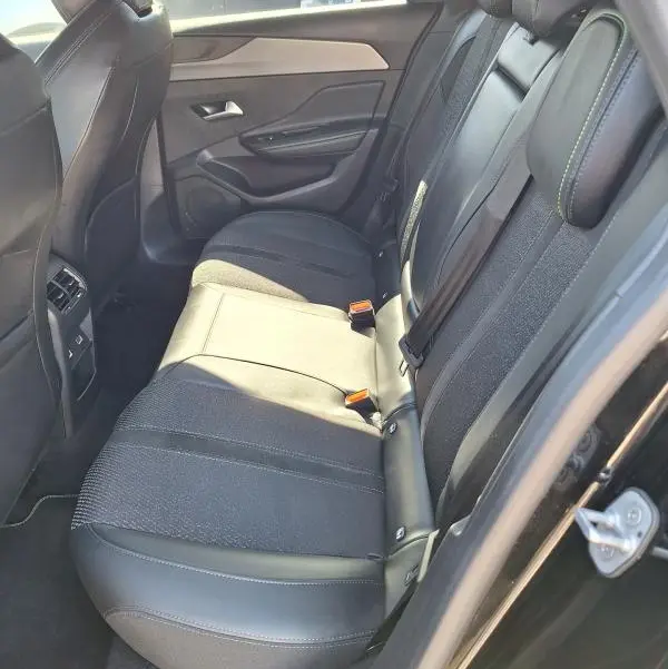 Vue intérieure côté droit des sièges arrière noirs en cuir et tissu du Peugeot 308 SW Hybrid 145 e-DCS6 GT 2025.