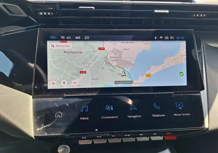 Vue rapprochée de l’écran tactile central du Peugeot 308 SW Hybrid 145 e-DCS6 GT affichant la navigation et les commandes multimédia.