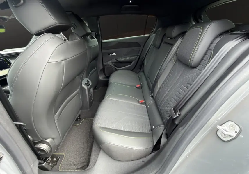 Vue intérieure côté droit sur la banquette arrière en cuir gris avec surpiqûres vertes d'une Peugeot 308 2026.