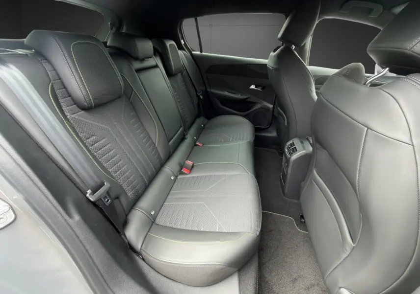 Vue intérieure arrière côté droit de la Peugeot 308 gris clair, montrant les sièges en cuir et tissu avec surpiqûres contrastées.