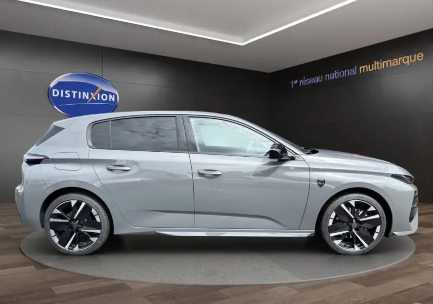 Vue de profil droit d'une Peugeot 308 gris clair 2026 avec jantes noires et détails modernes.