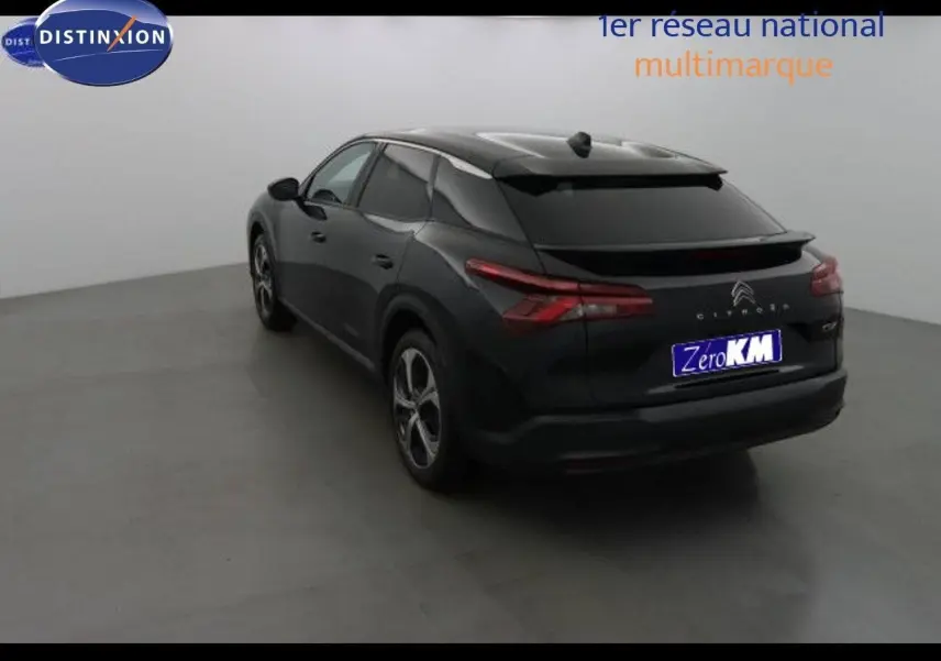 Vue 3/4 arrière droite d'une Citroën C5 X noire métal, avec feux arrière allongés et toit surélevé dans un studio.