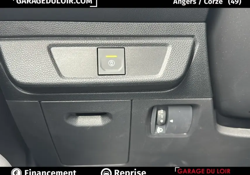 Détail intérieur du tableau de bord noir du Dacia Jogger Extreme+ Hybrid 140, avec commande de verrouillage centralisé.