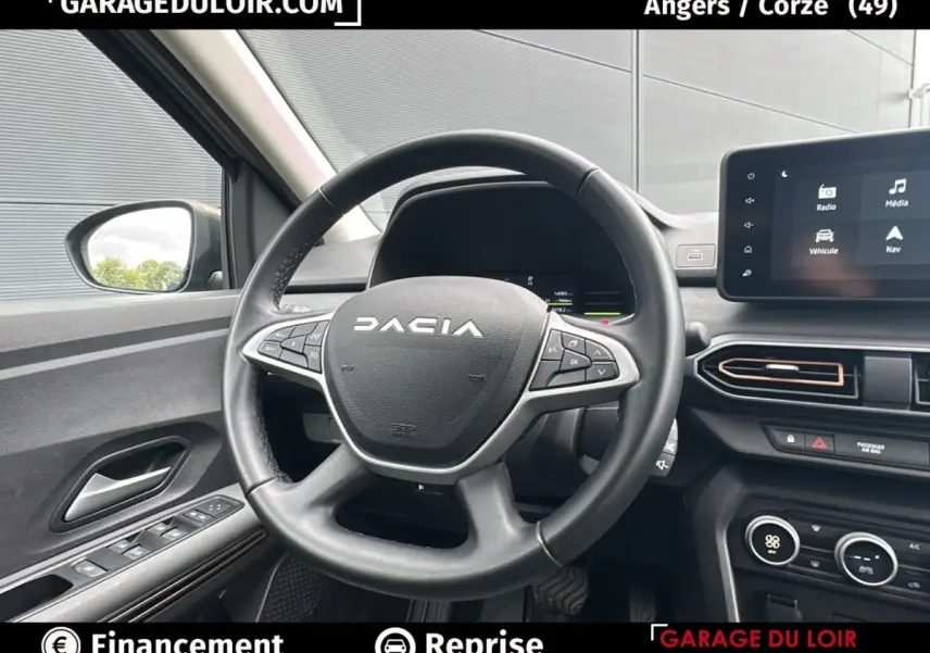 Vue intérieure centrée sur le volant noir du Dacia Jogger Extreme+ Hybrid 140 2025 avec tableau de bord et écran tactile visible.