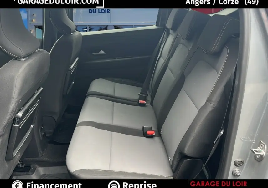 Vue latérale droite des sièges arrière gris clair et noir du Dacia Jogger Extreme+ Hybrid 140 2025 avec portes ouvertes.