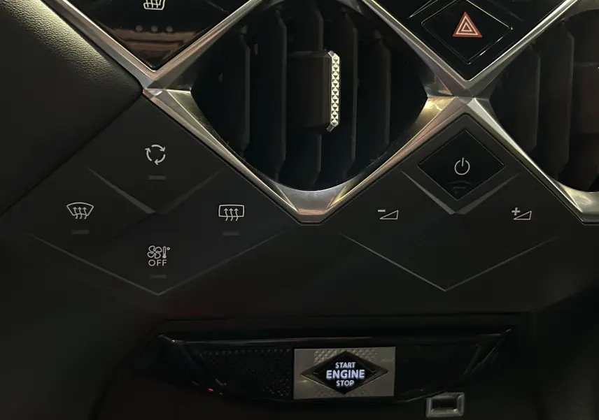 Détail du tableau de bord du DS3 Crossback bleu Millenium, avec commandes climatisation et bouton start/stop éclairé.