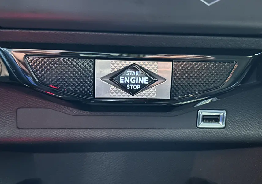 Bouton start/stop moteur en gros plan sur tableau de bord noir du DS3 Crossback Bleu Millenium, avec port USB adjacent.