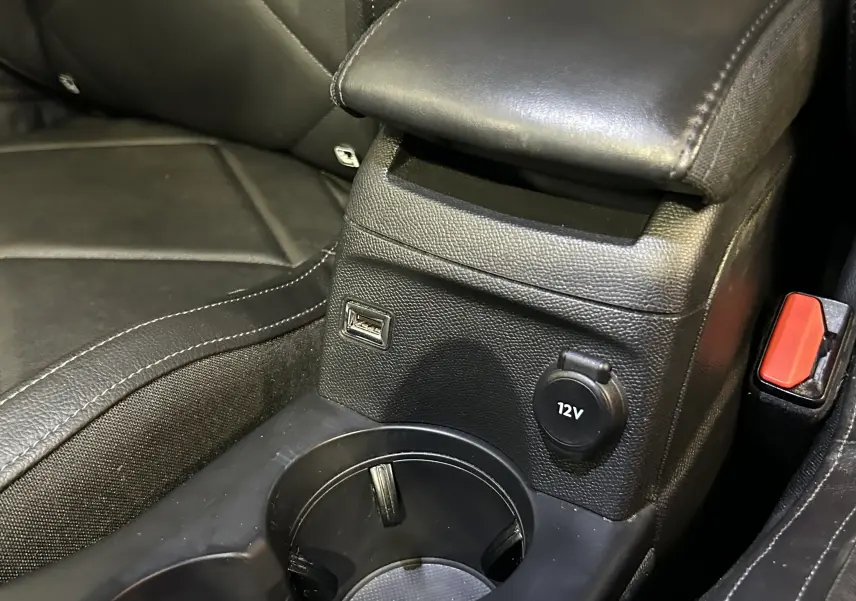 Gros plan sur la console centrale en cuir noir du DS3 Crossback avec prise USB et prise 12V visible.