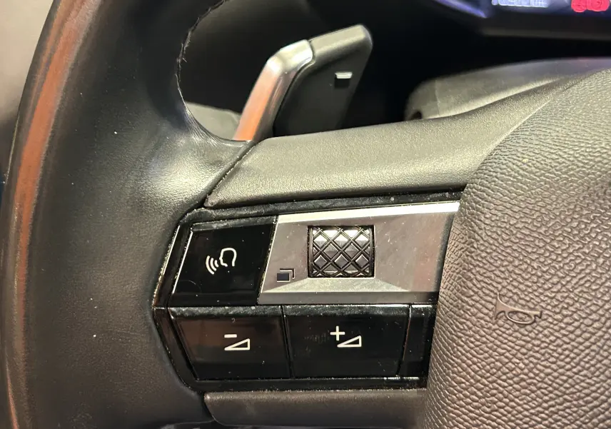 Gros plan sur les commandes de volume et reconnaissance vocale du volant en cuir noir du DS3 Crossback Bleu Millenium.