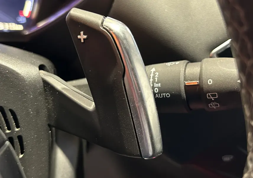 Gros plan sur la palette de changement de vitesse droite en plastique noir et chrome dans l’habitacle du DS3 Crossback Bleu Millenium.