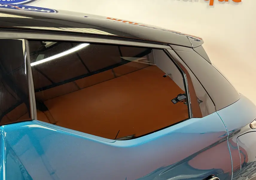 Vue latérale arrière droite du DS3 Crossback bleu Millenium avec toit noir brillant et vitres teintées.