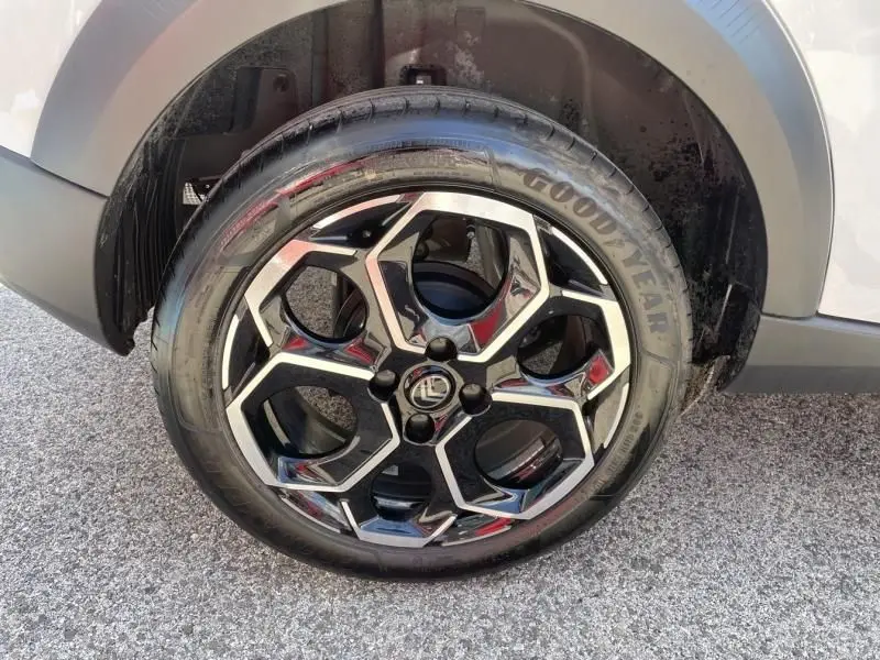 Gros plan sur la roue avant droite d’une Citroën C3 Nouvelle blanche 2025 avec jante alliage noire et argentée au design géométrique.