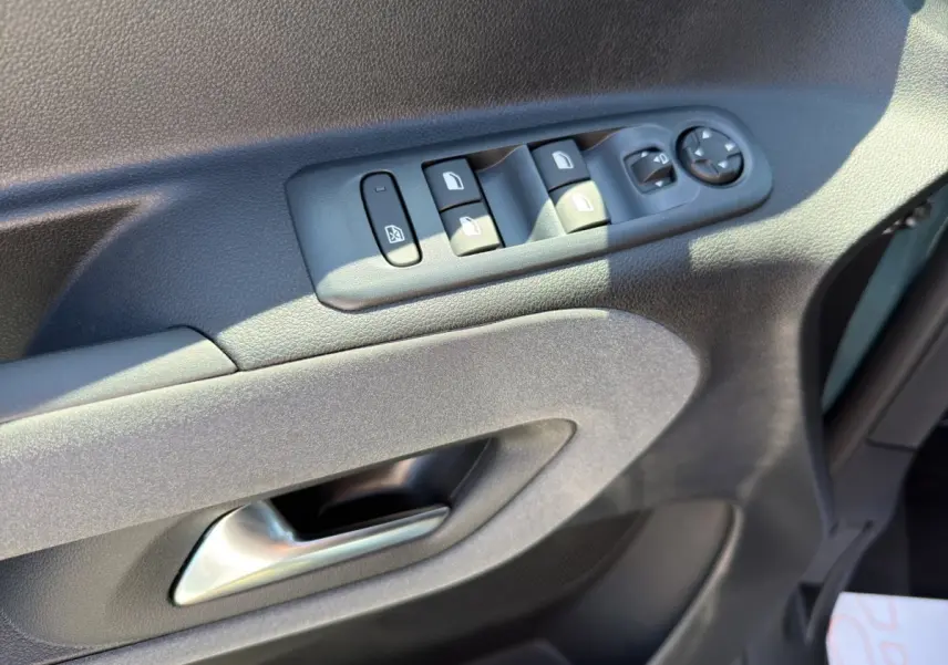 Détail de la porte côté conducteur du Peugeot Rifter bleu 2026 avec commandes électriques des vitres et rétroviseurs.