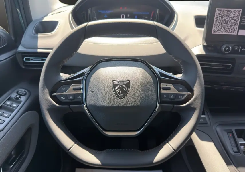 Vue rapprochée du volant cuir noir du Peugeot Rifter 2026 avec commandes multifonctions et tableau de bord numérique.