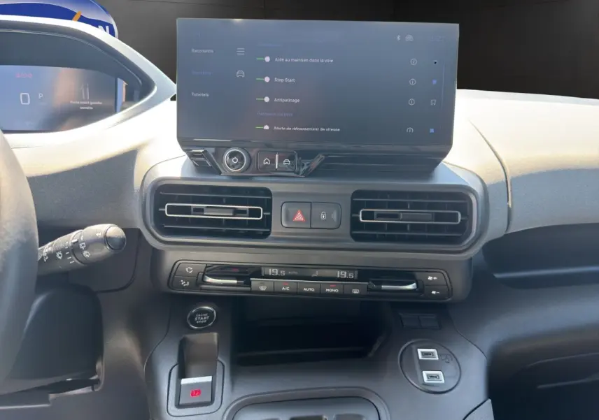 Vue intérieure du tableau de bord du Peugeot Rifter 2026, avec écran tactile central et commandes de climatisation.