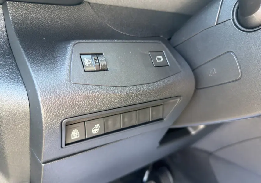 Détail intérieur côté conducteur du Peugeot Rifter bleu 2026 montrant les commandes de réglage des phares et sièges chauffants.
