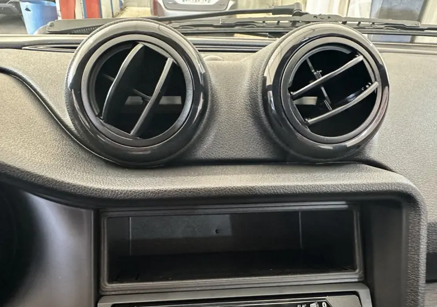 Gros plan sur les aérateurs ronds noirs du tableau de bord de l'AIXAM AMBITION 0.5 CITY PACK 2025.