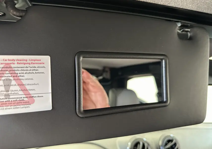 Miroir de courtoisie sur pare-soleil intérieur d'une Aixam Ambition 0.5 City Pack 2025 bleu, avec ventilation visible.