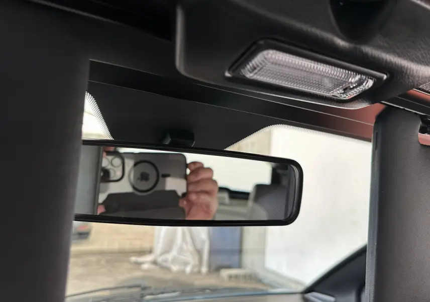 Vue intérieure du rétroviseur central d'une Aixam Ambition 0.5 City Pack 2025 avec caméra côté conducteur visible en reflet.