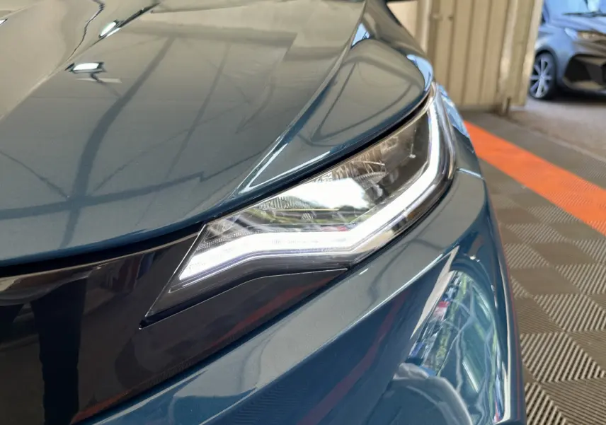 Gros plan sur le phare avant droit d'une Aixam Ambition 0.5 City Pack bleu 2025 avec éclairage LED distinctif.