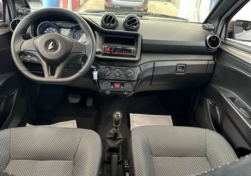 Vue intérieure avant de l'AIXAM AMBITION 0.5 CITY PACK 2025 avec tableau de bord noir et volant à trois branches.