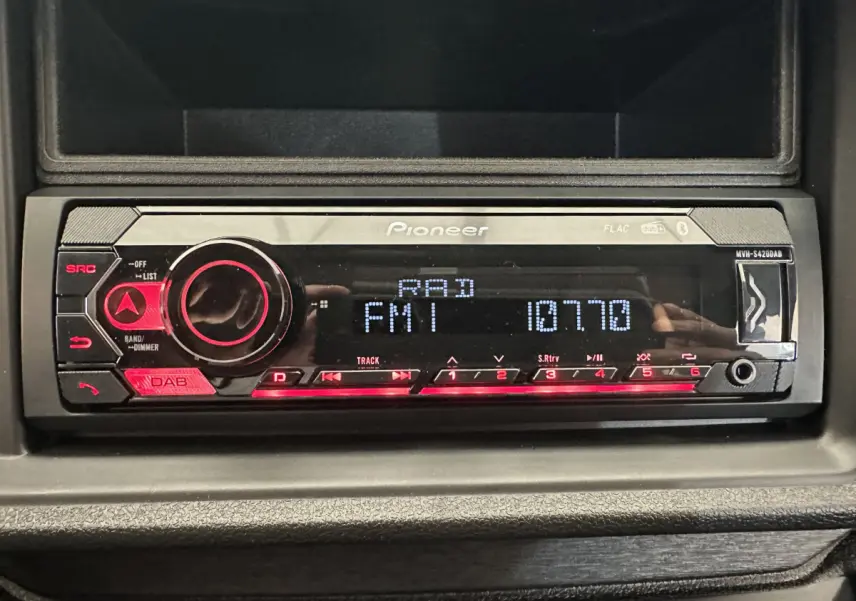 Gros plan sur la radio Pioneer intégrée dans le tableau de bord de l'AIXAM AMBITION 0.5 CITY PACK bleu 2025.